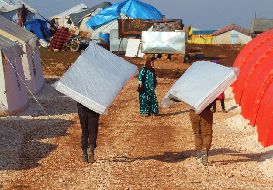 EVACUEES from a rebel-held area of Aleppo carry mattresses they received in the Kamouneh camp in Syr