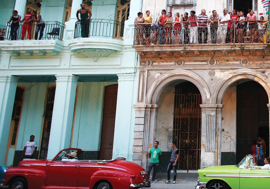 PEOPLE STAND on balconies on Paseo del Prado street in Havana, Cuba.