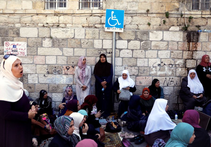Palestinian women shout slogans as they sit outside the Temple Mount at morning after Israel removed the new security measures there, in Jerusalem's Old City July 25, 2017. (Reuters)