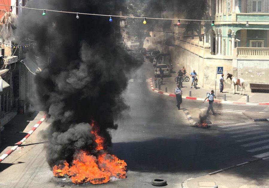 Protestors burn tires during clashes with police in Jaffa, July 29, 2017.