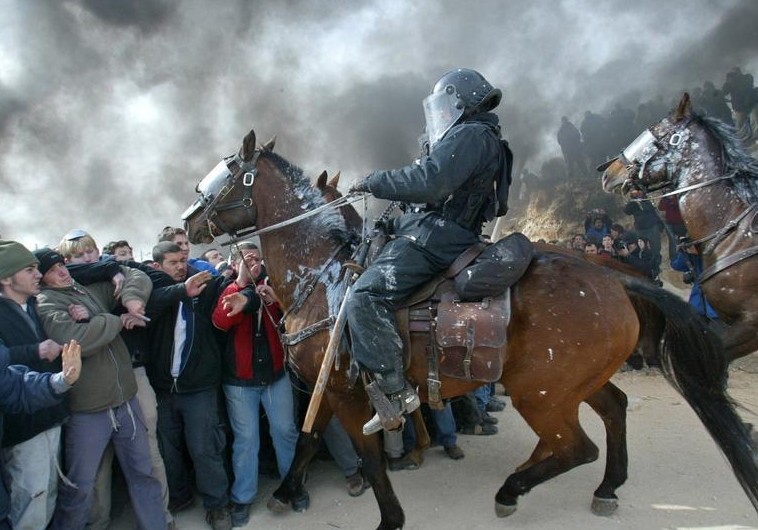 Mounted Israeli police scuffle with pro-settler supporters at the Amona outpost, February 1, 2006. Credit: Reuters