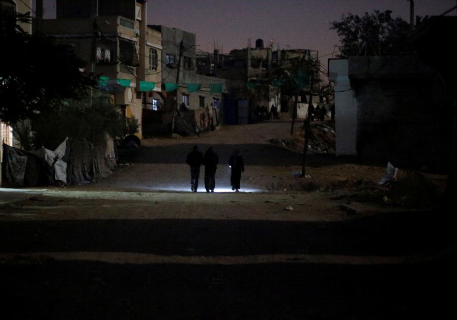 Palestinians walk on a road during a power cut in Beit Lahiya in the northern Gaza Strip. (REUTERS)