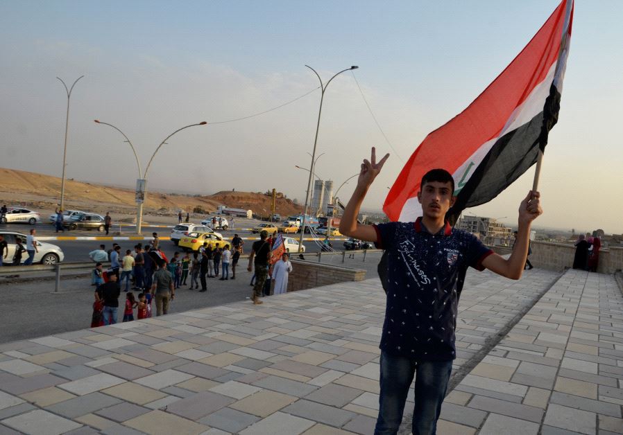 An Iraqi man waves his naitonal flag in the newly liberated city of Mosul, July 9 (Reuters)