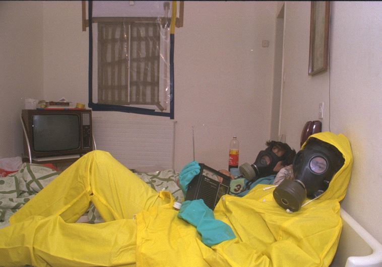 Israelis wear gas masks and hazmat suits at their home during the First Gulf War