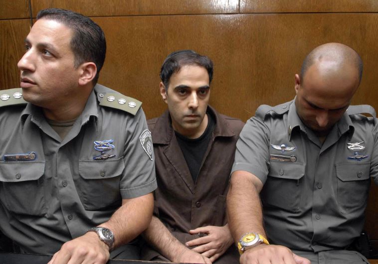 Israeli prison guards sit beside Yigal Amir (C), the assassin of Yitzhak Rabin