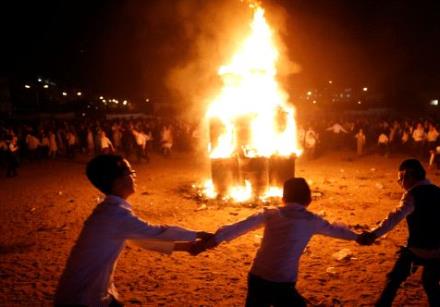 Ultra-Orthodox Jewish boys dance around a bonfire as they celebrate the Jewish holiday of Lag Ba'Ome