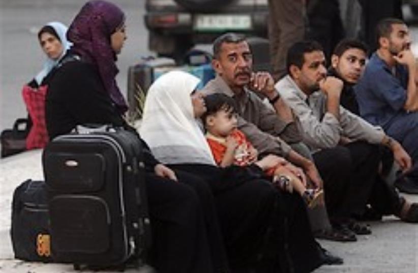 Palestinians wait next to their luggage to leave o (photo credit: AP)