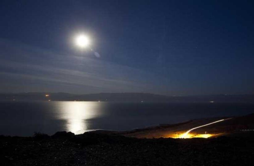 The moon shines in the night sky above the Dead Sea (photo credit: REUTERS)