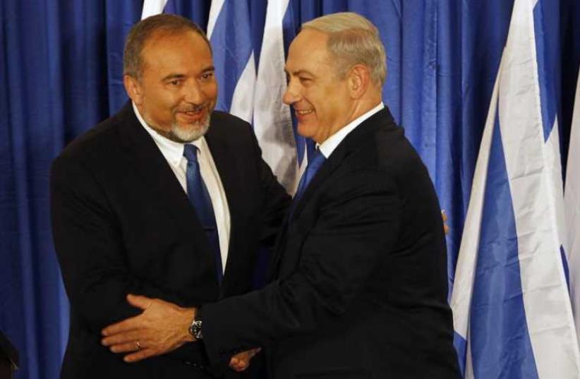 Prime Minister Benjamin Netanyahu (R) shakes hands with Foreign Minister Avigdor Liberman (photo credit: REUTERS)