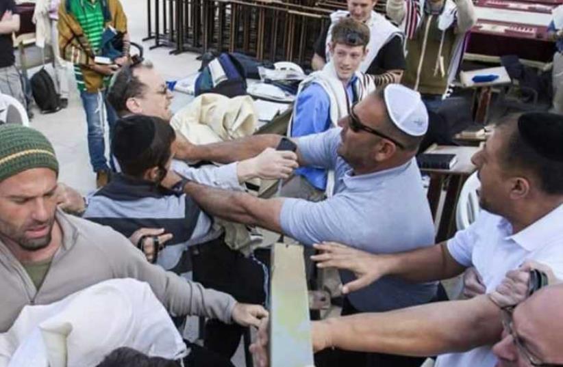 Charlie Kalech is attacked by an unidentified man at the Kotel on Monday (photo credit: COURTESY OF CHARLIE KALECH)