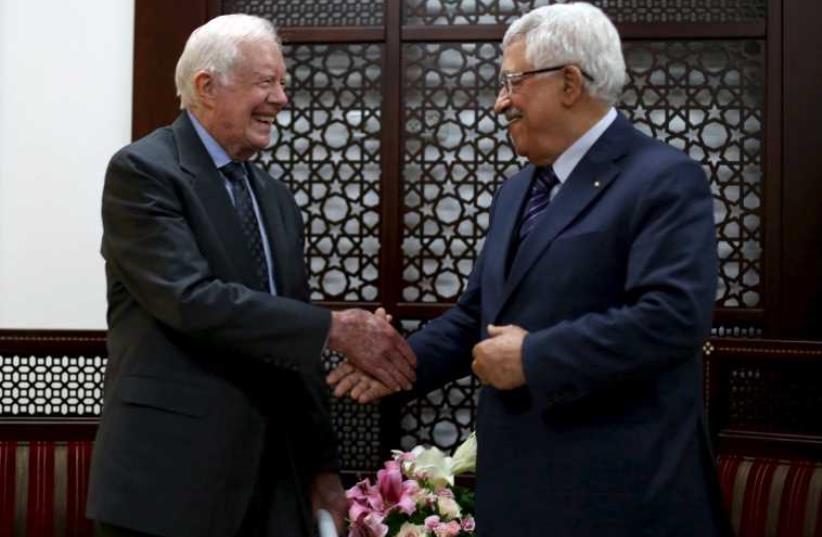 Palestinian President Mahmoud Abbas (R) shakes hands with former US president Jimmy Carter during their meeting in the West Bank city of Ramallah (photo credit: REUTERS)