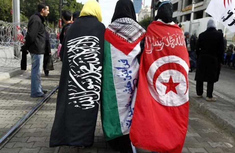 Girls walk the street dressed in (L-R) the Salafi, Palestinian and Tunisian flags during the second anniversary of the Tunisian Revolution in Tunis (photo credit: REUTERS)