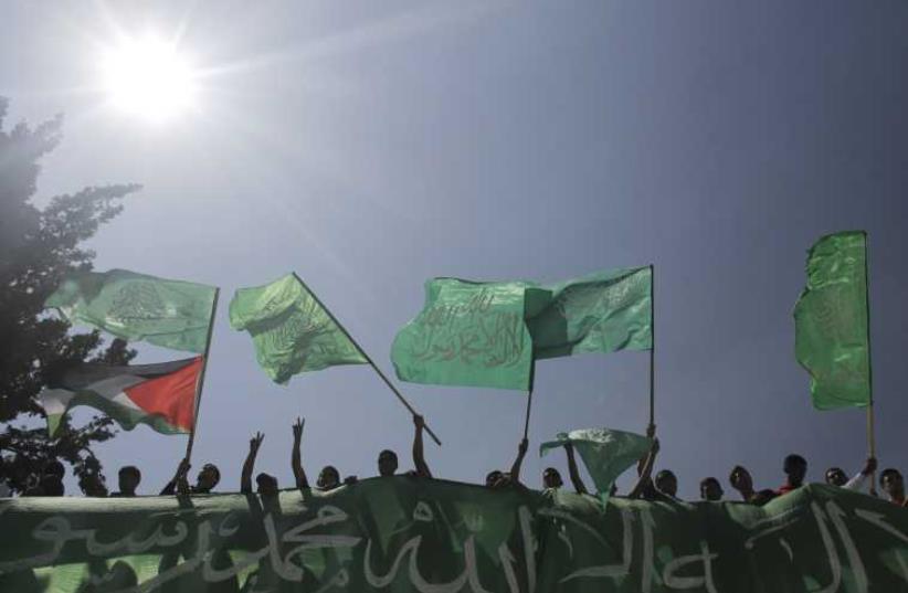  Palestinians wave Hamas and Palestinian flags (photo credit: REUTERS)