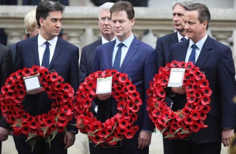 Ed Miliband (L) who resigned as leader of the Labour Party, Nick Clegg who resigned as leader of the Liberal Democrats, and Britain's Prime Minister David Cameron (R) carry wreaths of poppies as they pay tribute at the Cenotaph to mark the 70th anniversary of VE Day in London (photo credit: REUTERS)