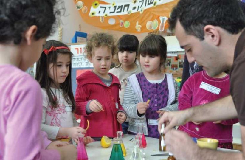 Dr. Assaf Marom teaches kindergarten students about acids and alkaline substances at a Science Day event (photo credit: SCIENCE, TECHNOLOGY AND SPACE MINISTRY)