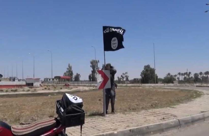 ISIS flag flying in Ramadi Iraq (photo credit: AAMAQ NEWS VIA YOUTUBE / AFP)