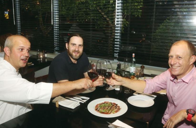Designer Yaron Loubaton (right) raises his glass with chef Moti Ahana (left) and interviewer Asaf Finkelstein. (photo credit: ILLUSTRATIVE: MARC ISRAEL SELLEM)