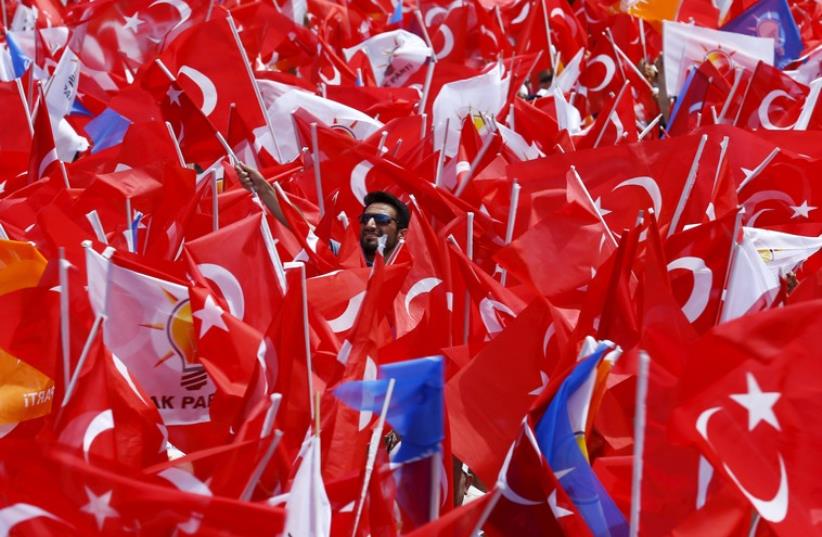 Supporters of the ruling AK Party wave Turkish national and party flags at an election rally for Turkey's June 7 parliamentary election, in Antalya, Turkey, June 6, 2015 (photo credit: REUTERS)
