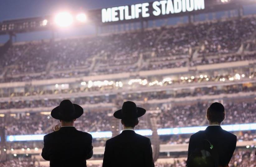 Orthodox Jews gather to celebrate the completion of study of the entire Talmud religious text in East Rutherford, New Jersey (photo credit: AFP PHOTO)