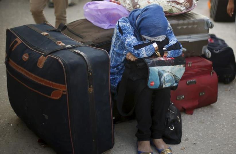 A Palestinian woman waits for a travel permit to cross into Egypt (photo credit: REUTERS)