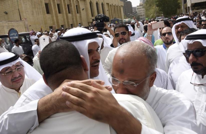 Kuwaiti Information Minister Sheikh Salman al-Humoud al-Sabah (C) consoles worshipers outside the Imam Sadiq Mosque after a suicide bomb attack following Friday prayers (photo credit: REUTERS)