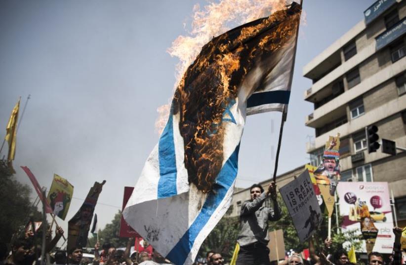 Iranian protestors burn an Israeli flag during a demonstration in Tehran on July 25, 2014 to mark the Quds Day (photo credit: BEHROUZ MEHRI /AFP)