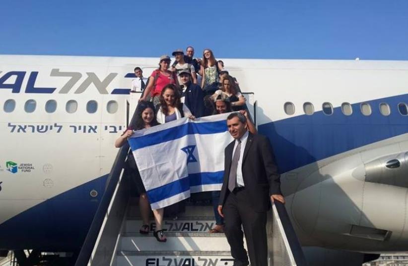 Zeev Elkin welcomes olim on the 53rd Nefesh B'Nefesh flight as it lands in Israel (photo credit: STEVE LINDE)