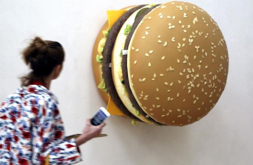 A woman looks at a creation by Tom Friedman named 'Big Big Mac' during the unveiling of the Arts & Food exhibition at the Triennale, as part of the next Expo 2015, in downtown Milan (photo credit: REUTERS)