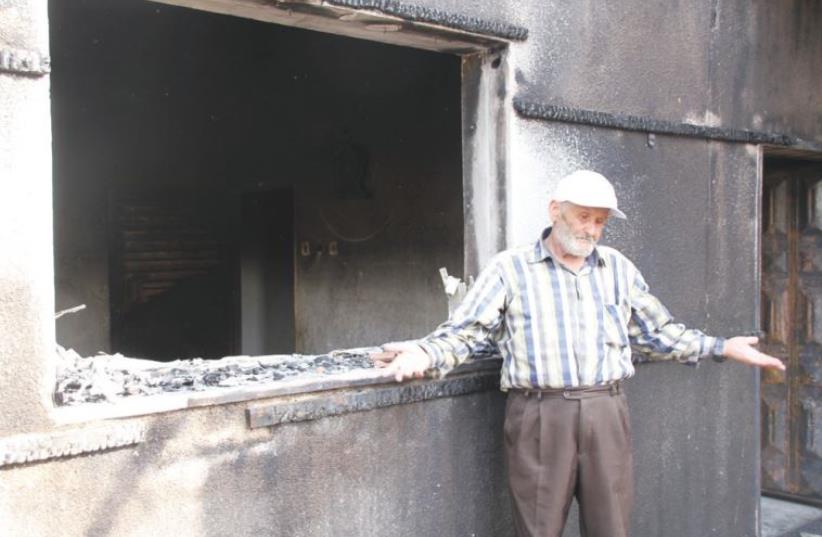 RASHID DAWABSHA stands outside his son Mamoun’s torched home in the Arab village Duma on Sunday (photo credit: TOVAH LAZAROFF)