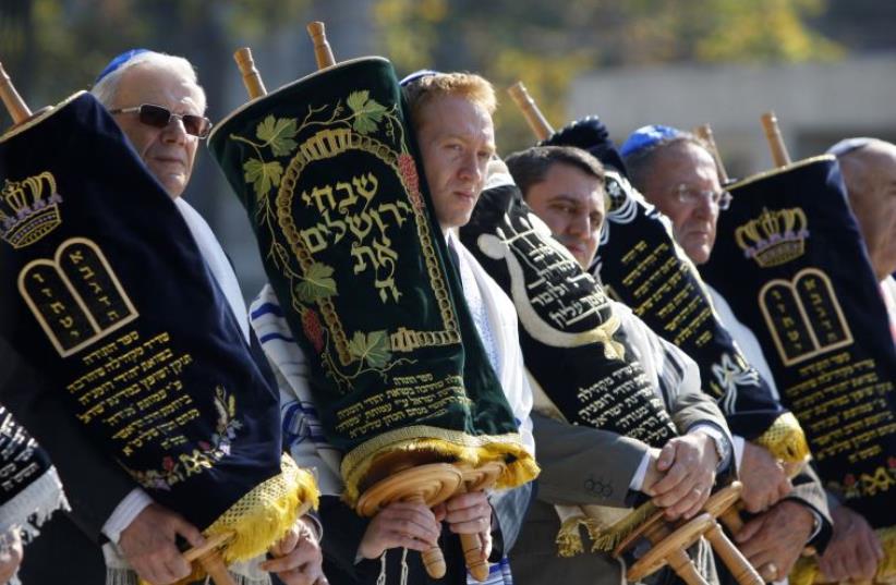 Jewish community members from Romania hold Torah scrolls during the inauguration ceremony for the Holocaust memorial in Bucharest October 8, 2009. (photo credit: REUTERS)
