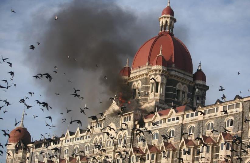 Pigeons fly near the burning Taj Mahal hotel in Mumbai November 27, 2008. (photo credit: REUTERS)