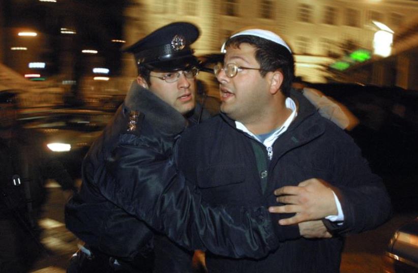 A policeman arrests Israeli right-wing activist Itamar Ben Gvir during a 'Peace Now' demonstration in Jerusalem (photo credit: GALI TIBBON / AFP)