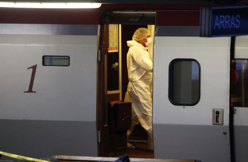 French investigating police in protective clothing collect clues inside the Thalys high-speed train where shots were fired in Arras (photo credit: REUTERS)