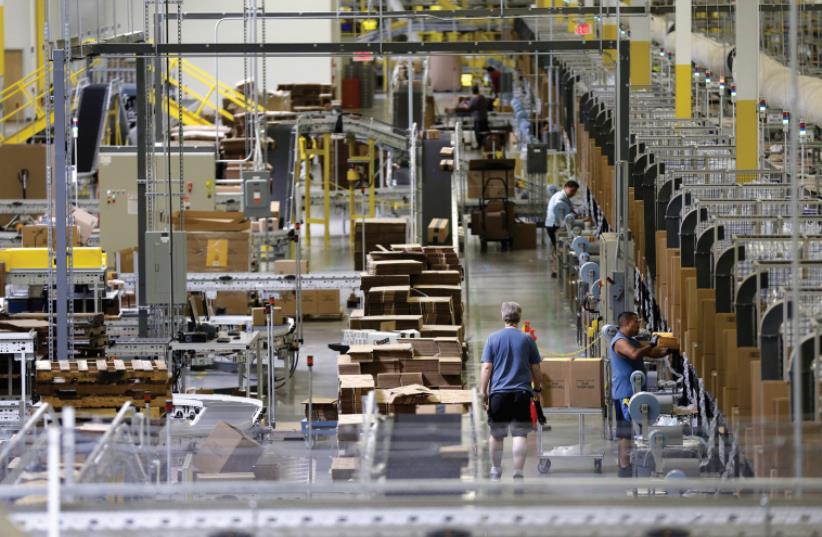 WORKERS SORT products at an Amazon Fulfillment Center in Tracy, California early this month (photo credit: REUTERS)