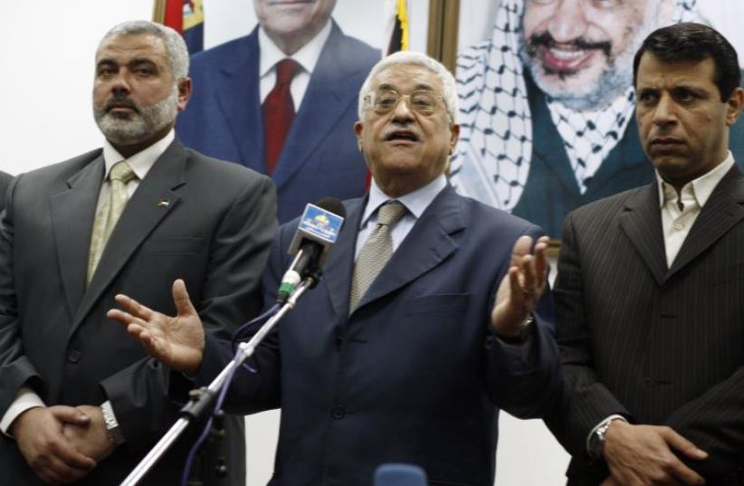 Palestinian president Abbas stands between PM Haniyeh and senior Fatah leader Dahlan in Gaza (photo credit: SUHAIB SALEM / REUTERS)