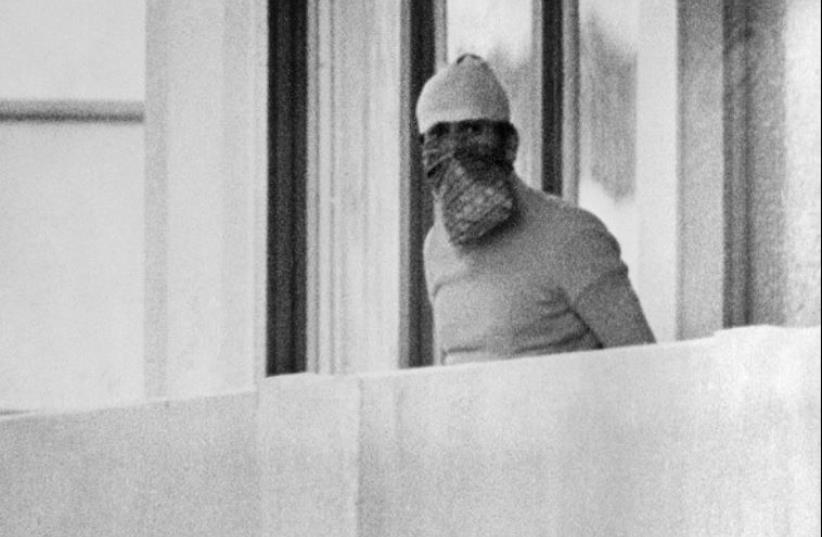 A member of the Palestinian terrorist group Black September appears on the balcony of the Israeli house at the Munich Olympic village on September 5, 1972 (photo credit: AFP PHOTO)
