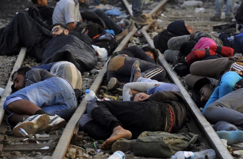 DATE IMPORTED: September 06, 2015 Refugees and migrants sleep on the railway tracks close to the borders of Greece with Macedonia, near the village of Idomeni, September 6, 2015.  (photo credit: REUTERS)