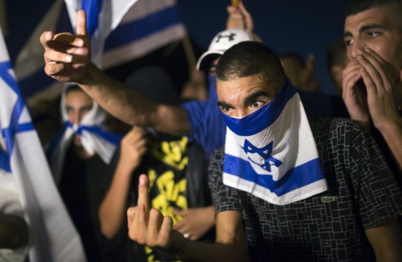 A right-wing Israeli activist gestures during a counter-protest against supporters of hunger-striking Palestinian detainee Mohammed Allan (photo credit: REUTERS)
