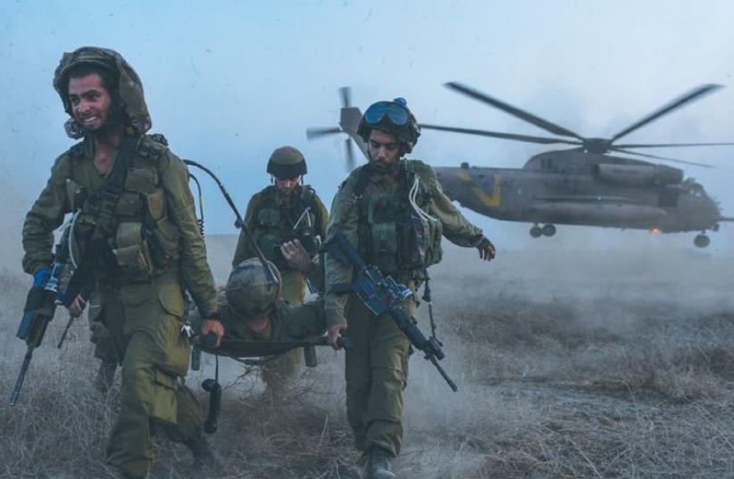Members of the 188th Armored Division practice evacuating a wounded soldier during a drill on the Golan Heights  (photo credit: IDF SPOKESMAN’S UNIT)