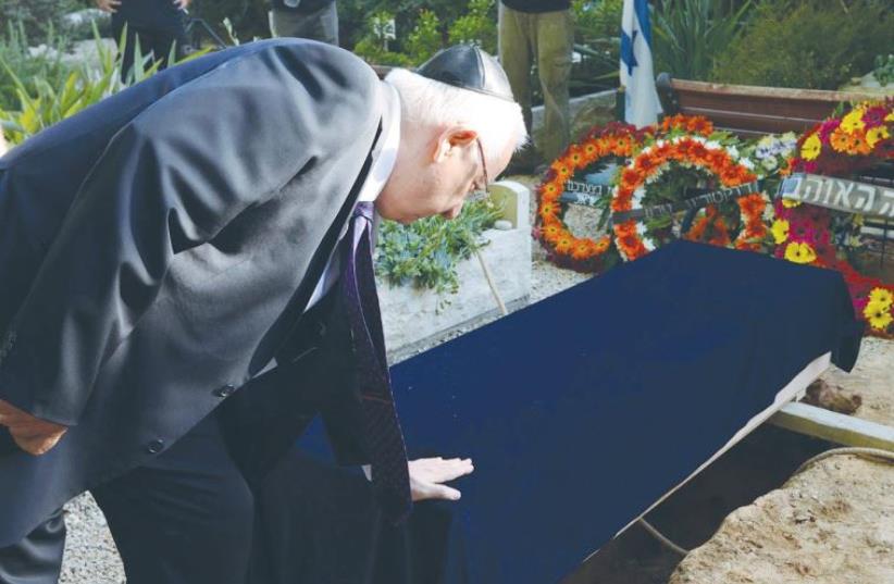 PRESIDENT REUVEN RIVLIN pays his respects at the funeral of former Supreme Court justice Mishael Cheshin at Kibutz Givat Hashlosha (photo credit: MARK NEYMAN / GPO)