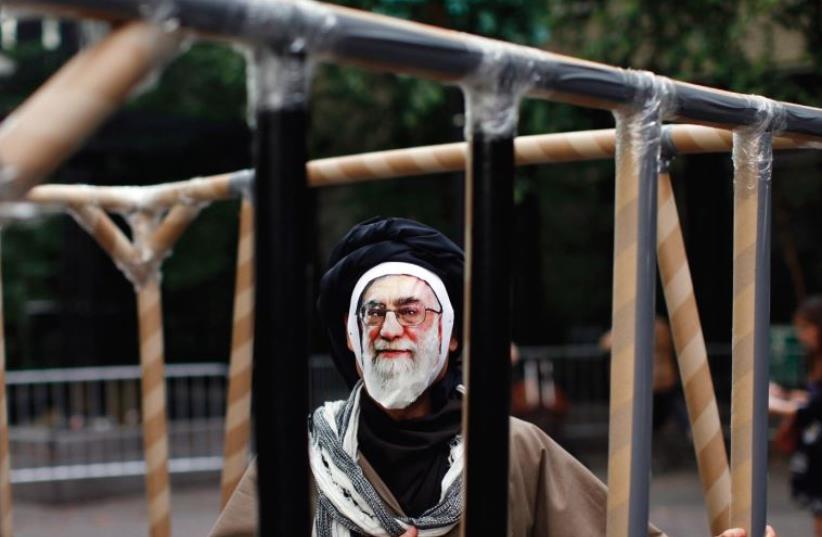 A PROTESTER wearing a mask depicting Iran’s Supreme Leader Ayatollah Ali Khamenei stands in a fake jail during protests outside the UN headquarters in New York in 2011. Iran’s human rights abuses seem to be off the agenda this year. (photo credit: REUTERS)
