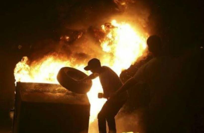 Pro-Palestinian demonstrators light garbage bin on fire during protests in Jaffa, October 6, 2015 (photo credit: Courtesy)