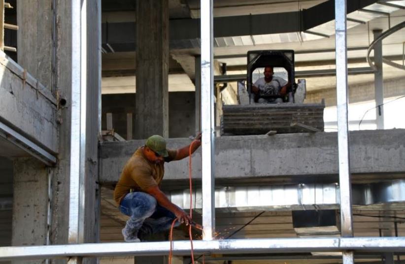 Construction workers build new mall at the Gush Etzion junction in the West Bank (photo credit: TOVAH LAZAROFF)