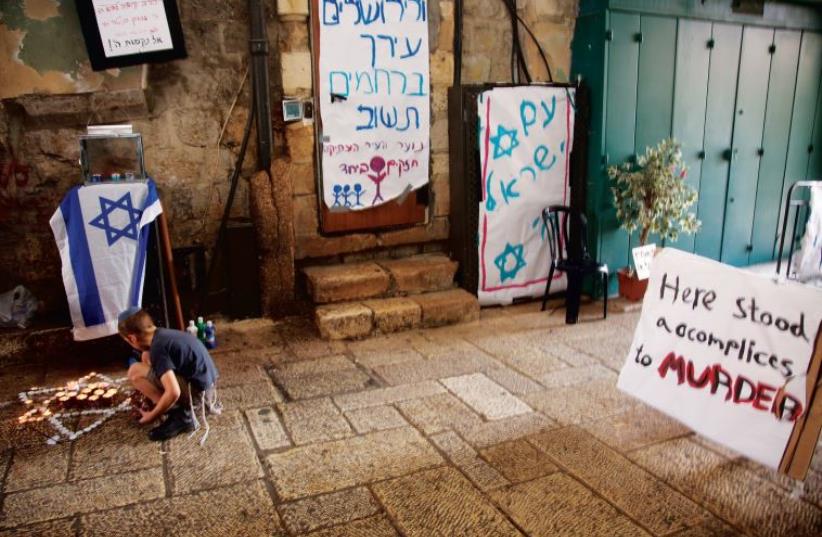A child pays homage at the site in Jerusalem’s Old City where Rabbi Nehemia Lavi and Aharon Banita were stabbed to death on October 3 (photo credit: MARC ISRAEL SELLEM/THE JERUSALEM POST)