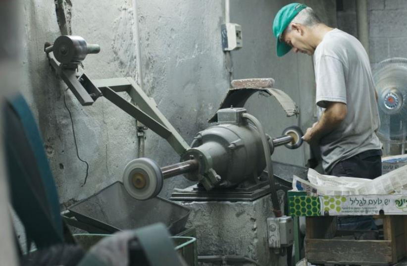 A metalworker in Florentin’s workshop district. (photo credit: ANNA LOSHKIN)