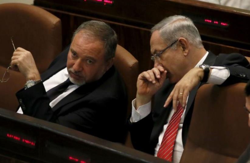 Prime Minister Benjamin Netanyahu (R) confers with Yisrael Beytenu chief Avigdor Liberman in the Knesset (photo credit: AFP PHOTO)