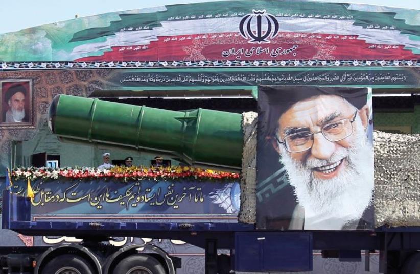 A MILITARY truck carrying a missile and a picture of Iran’s leader Ayatollah Ali Khamenei drives in a parade marking the anniversary of the Iran-Iraq war in Tehran (photo credit: REUTERS)