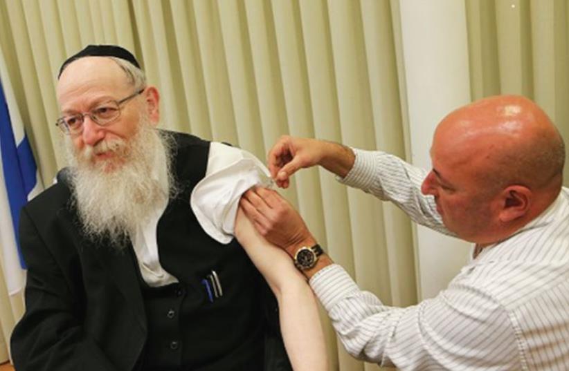 HEALTH MINISTER Yaacov Litzman receives his flu shot from Prof. Itamar Grotto (photo credit: HEALTH MINISTRY)