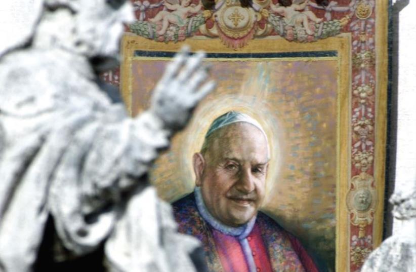 A TAPESTRY with the image of Pope John XXIII hangs on the facade of St. Peter’s facade during a beatification ceremony in 2000. (photo credit: REUTERS)