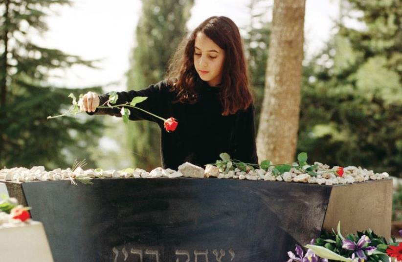 A girl lays a red rose on the grave of slain prime minister Yitzhak Rabin on Jerusalem’s Mount Herzl (photo credit: REUTERS)